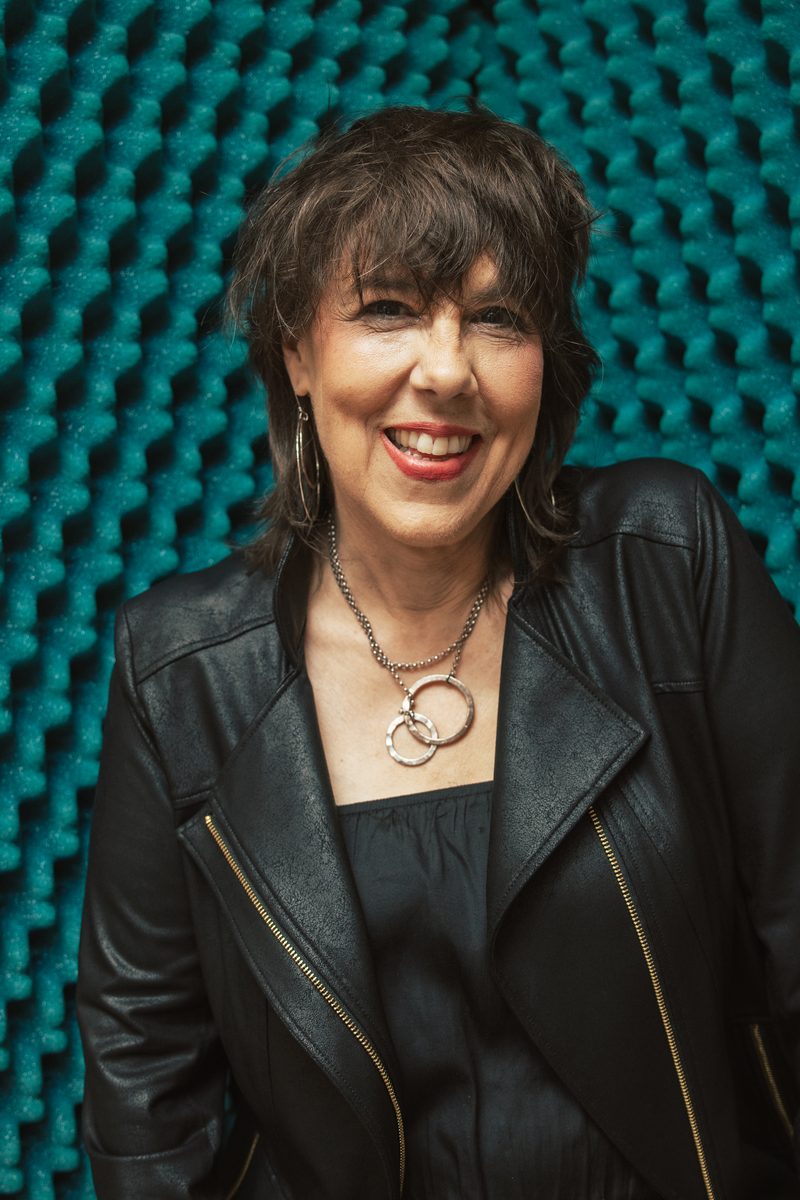 Beth Falcone in a black leather jacket in a recording studio.