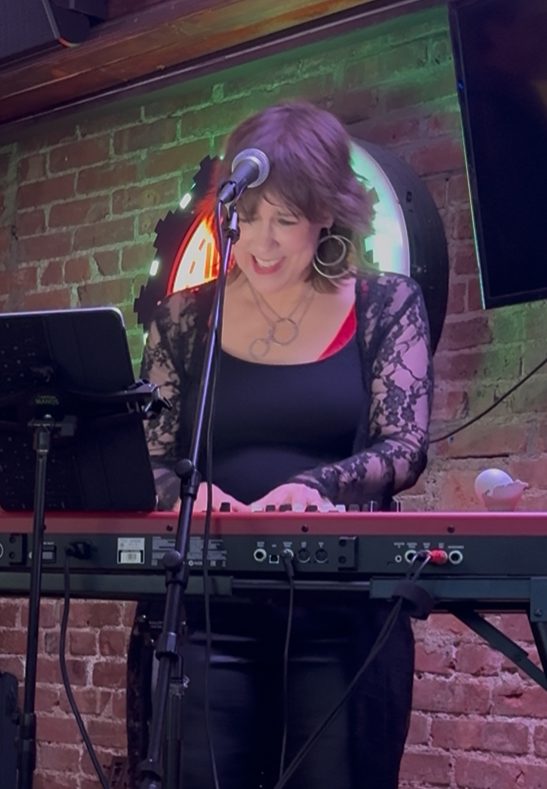 Beth singing at the keyboard at Blondie's.